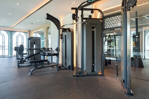 A gym with various exercise equipment, large windows, and a modern interior design. - Title Legendary D606 (Tambon Choeng Thale)