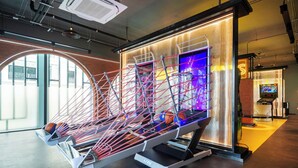 A modern interior with a unique suspended structure, a digital display, and a visible gaming machine.