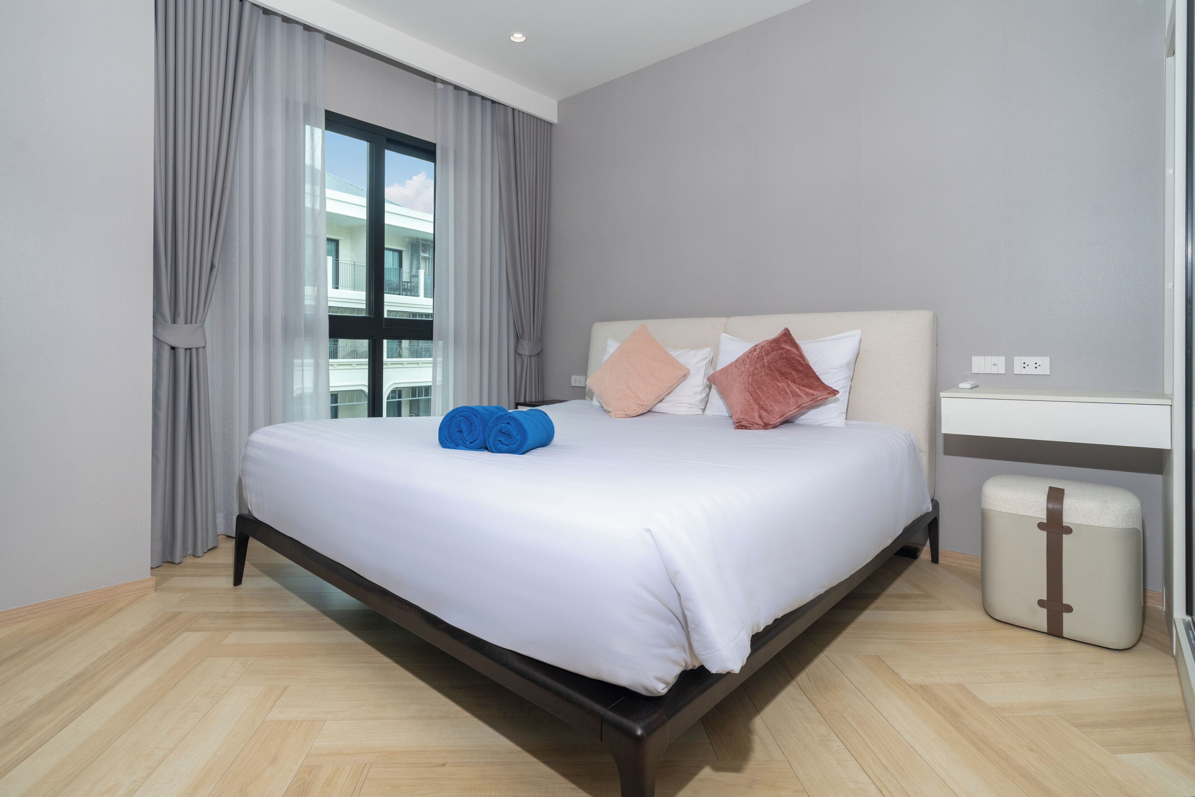 Een hotelkamer met een groot bed, een nachtkastje, een lamp en uitzicht.