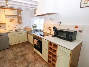 Una cocina equipada con lavavajillas, estufa, microondas y diversos utensilios de cocina.
