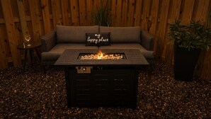 Eine Holzterrasse mit einer Sitzecke und einem Feuerkorb.