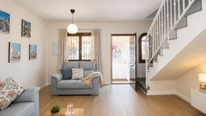 Una sala de estar con un sofá, una mesa de centro y una escalera.