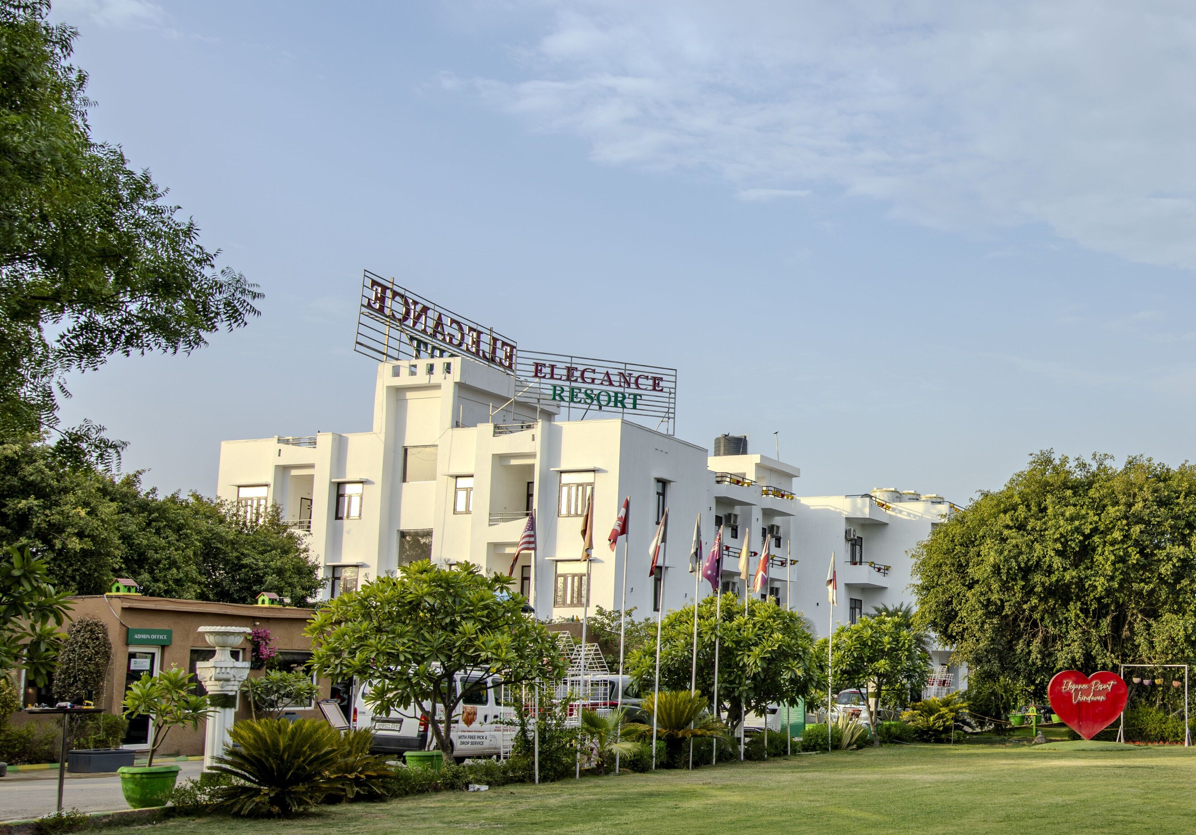 Um edifício com uma placa que diz 'ELEGANCE RESORT' e várias bandeiras.