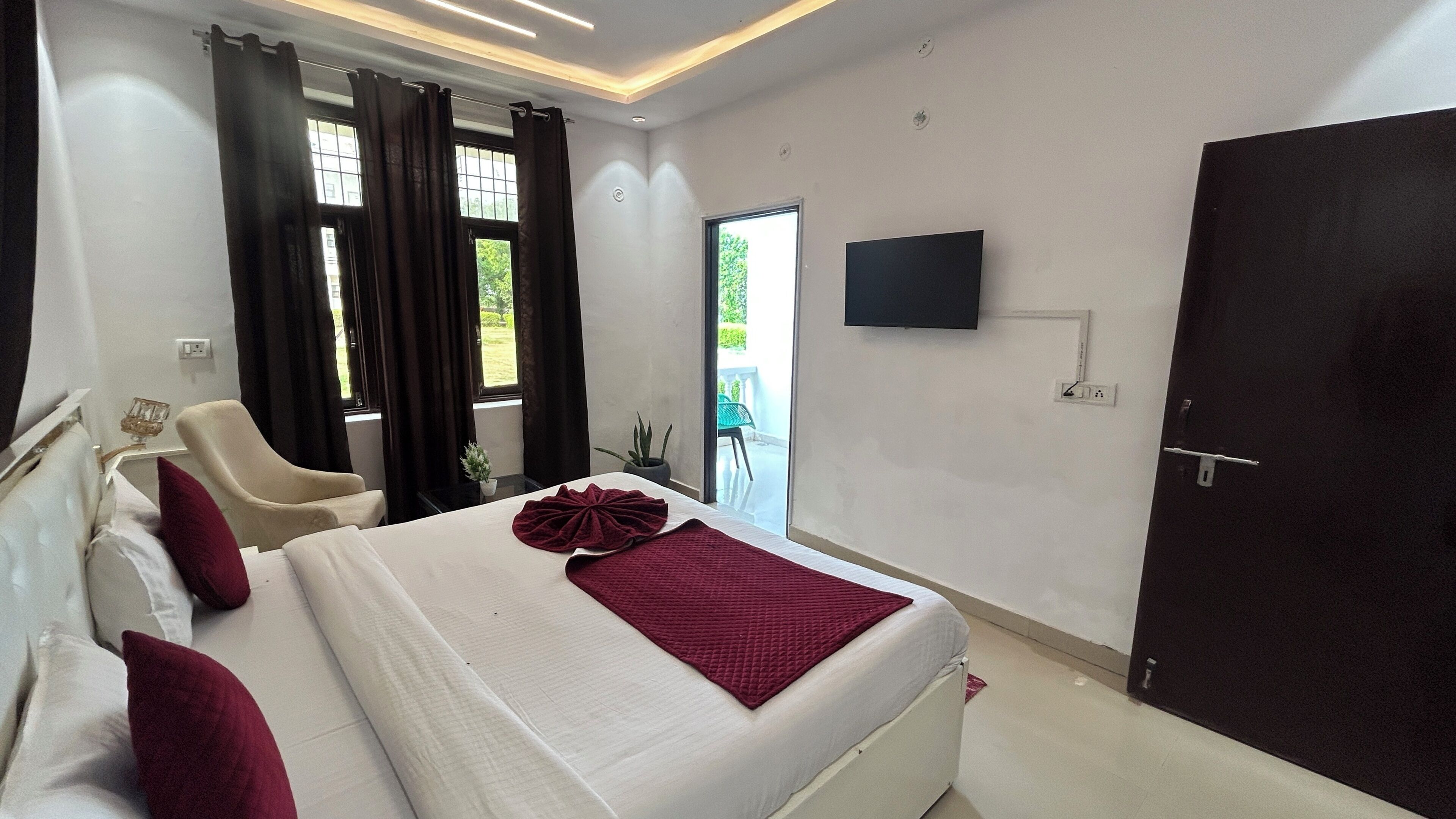 Une chambre d’hôtel avec un lit, une chaise, une télévision et une porte.