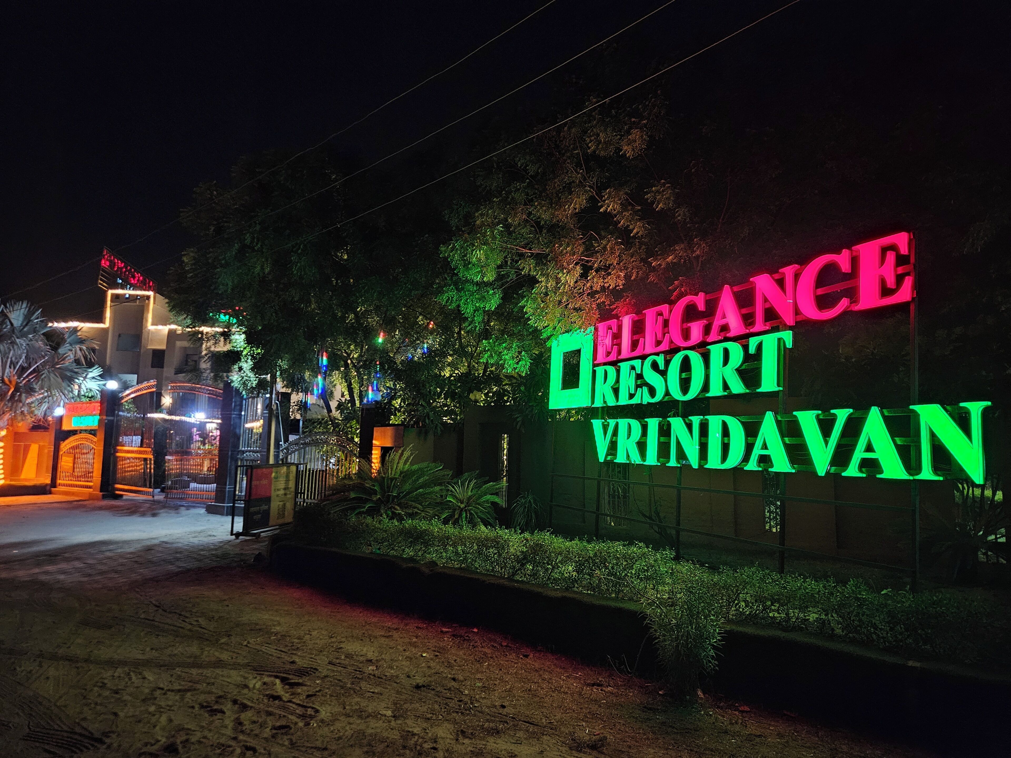 A sign for Elegance Resort with a gated entrance.