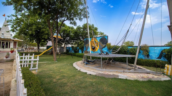 A playground with a slide, swings, and a mural.