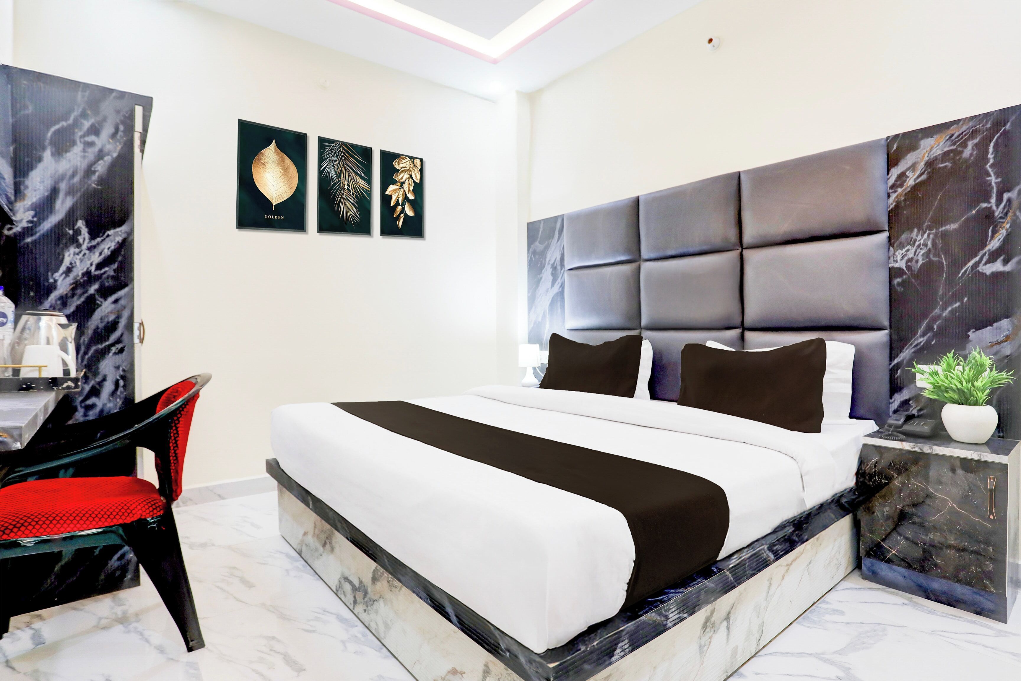 A modern bedroom with a large bed, a desk, and a chair.