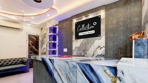 A reception desk with a marble design, a sign reading 'Collection Company-Serviced', and a blue decorative element. - Super OYO Collection O Subedarganj (Prayagraj)