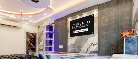 A reception desk with a marble design, a sign reading 'Collection Company-Serviced', and a blue decorative element.