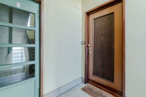 A door with a doorknob and a mat with 'WELCOME' written on it. - A modern 57sqm flat, perfect for 4 guests, located on the first floor of a building with an elevator (stairs to reach it).The property is situated in the San Salvario district, one of Turin's central neighborhoods, renowned for its Art Nouveau and Baroqu (Turin)