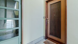 A door with a doorknob and a mat with 'WELCOME' written on it. - A modern 57sqm flat, perfect for 4 guests, located on the first floor of a building with an elevator (stairs to reach it).The property is situated in the San Salvario district, one of Turin's central neighborhoods, renowned for its Art Nouveau and Baroqu (Turin)