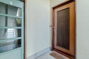 A door with a doorknob and a mat with 'WELCOME' written on it. - A modern 57sqm flat, perfect for 4 guests, located on the first floor of a building with an elevator (stairs to reach it).The property is situated in the San Salvario district, one of Turin's central neighborhoods, renowned for its Art Nouveau and Baroqu (Turin)
