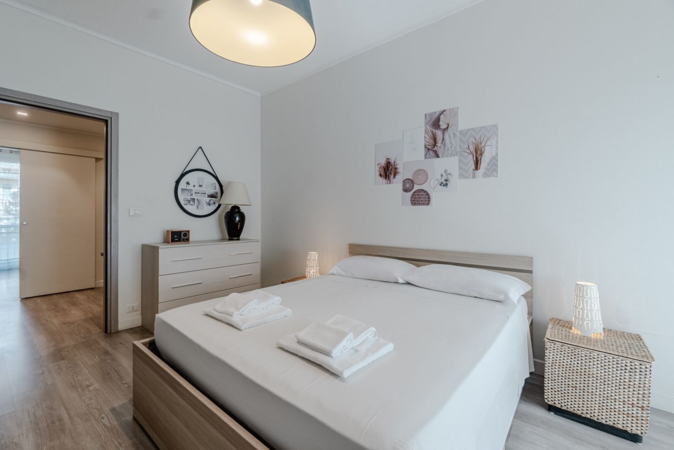 Ein zeitgemäßes Schlafzimmer mit Bett, Nachttischen und Wandkunst.