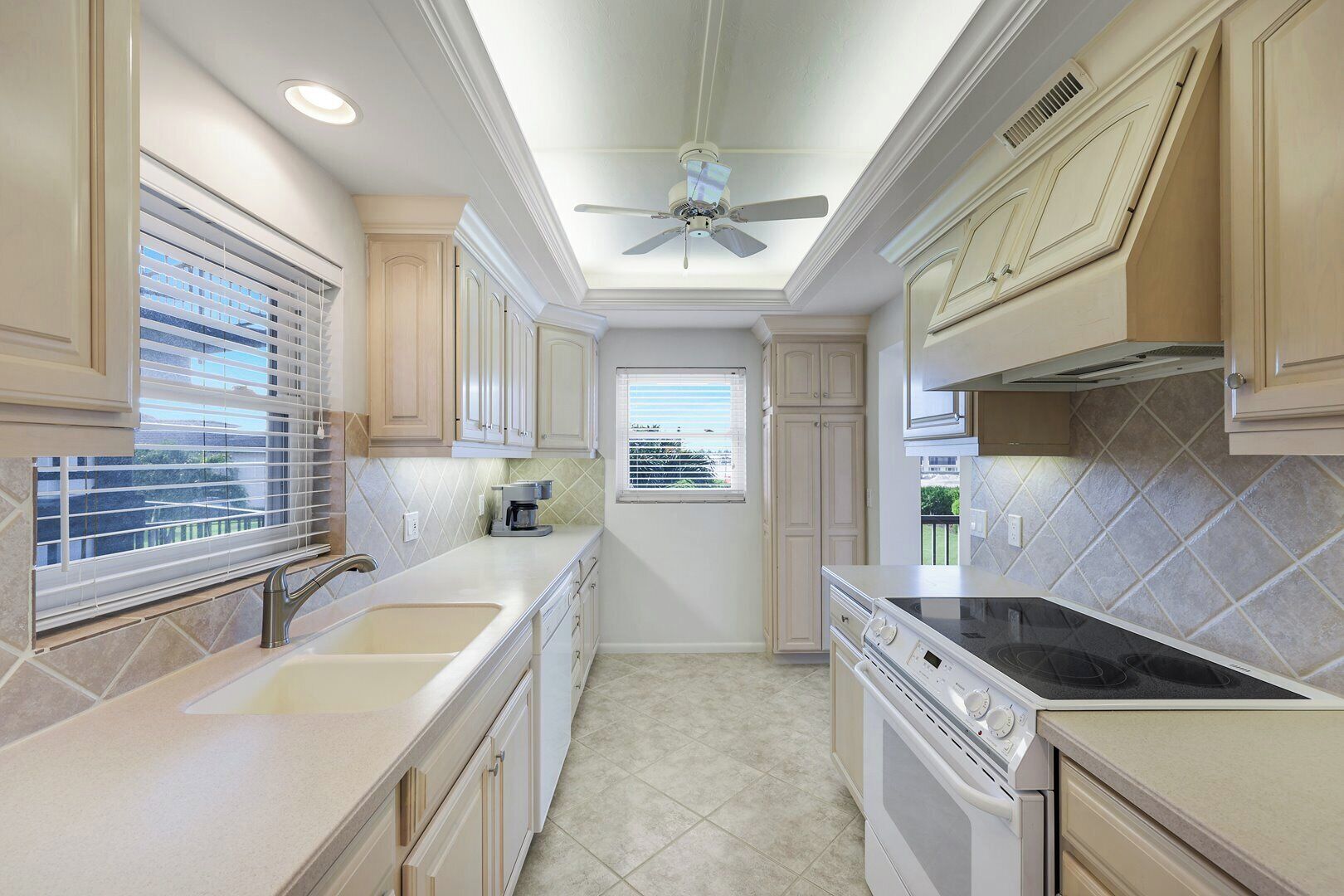 A kitchen with a central island, a built-in oven, and a ceiling fan.