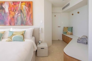 Una habitación de hotel con cama, mesita de noche y un espejo grande.