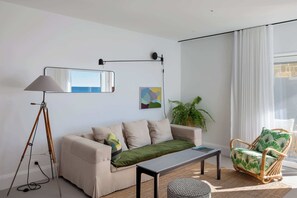 A modern living room with a sofa, a floor lamp, a table, and a chair. - Bower Break at Fairy Bower (Manly)