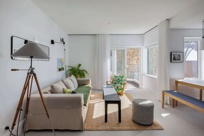 A modern living room with a sofa, a coffee table, a floor lamp, and a chair. - Bower Break at Fairy Bower (Manly)