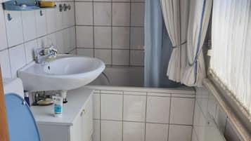 A small bathroom with a toilet, sink, and shower.