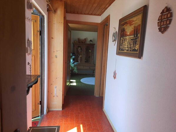 A hallway with a wooden door, a cabinet with glass doors, and a framed picture on the wall. - Cozy Wooden Cabin in the Odenwald | Garden | Hiking Trails | Free Parking (Wald-Michelbach)