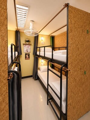 A bunk room with three beds, a ceiling fan, and a small window with blinds. - J cafe & hostel (Chiang Mai)
