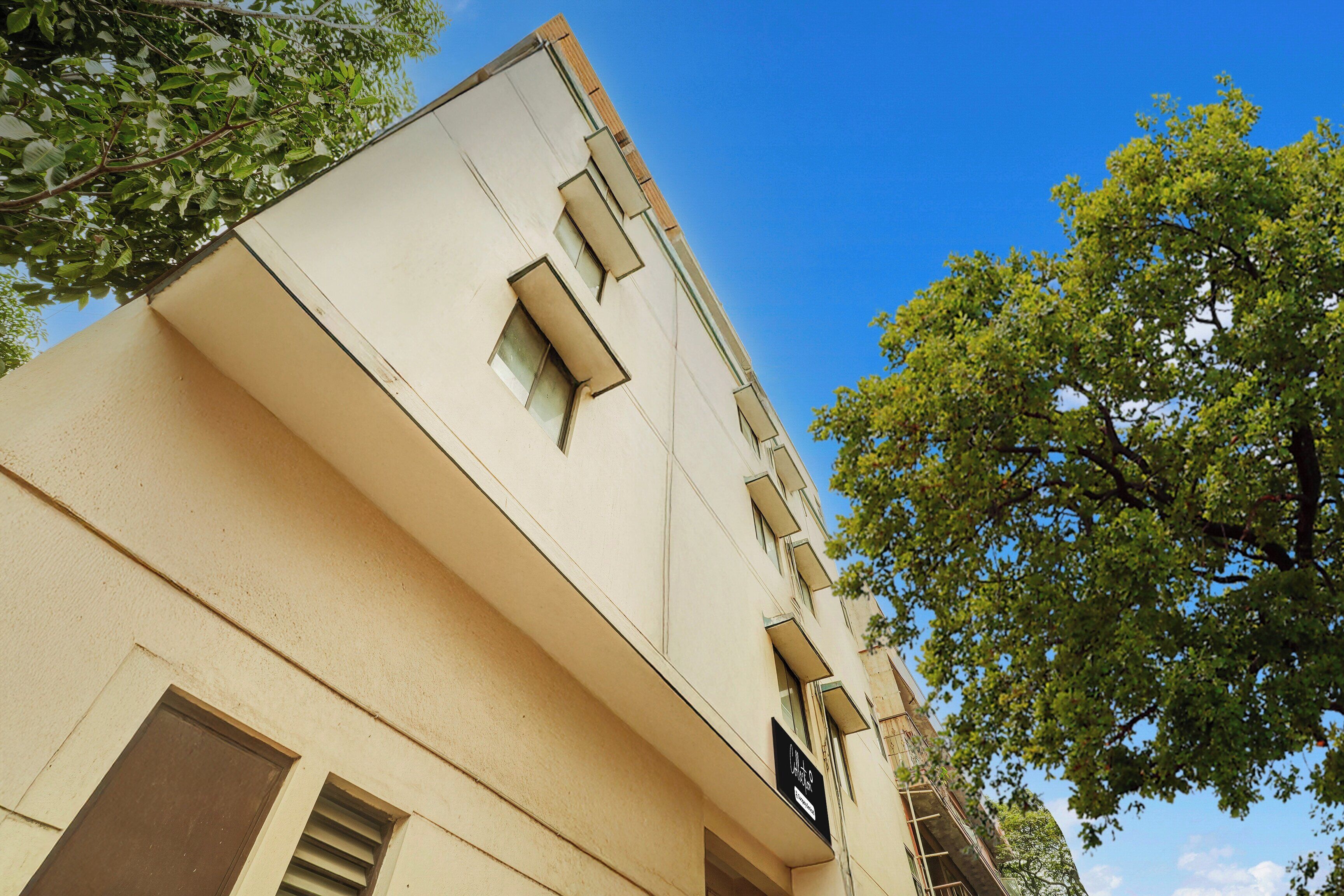 Un edificio con fachada color beige, múltiples ventanas y una señal visible.