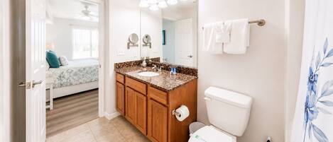 Une salle de bain avec des toilettes, un lavabo et un miroir.