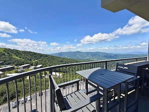A balcony with a view of a parking lot and distant mountains. - Escape to the beauty of Sugar Mountain in this comfortable 2-bedroom condo (Sugar Mountain)