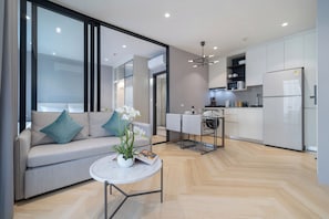Un apartamento moderno con sala de estar, kitchenette y comedor.