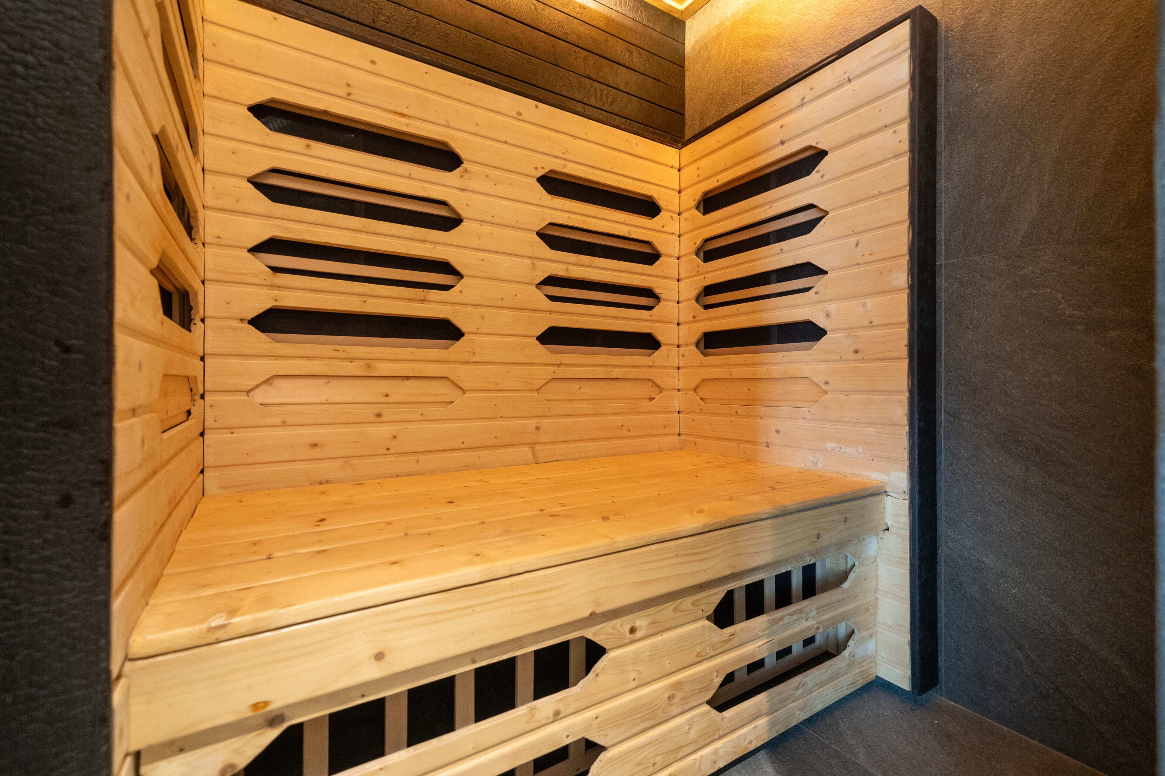 A sauna with a wooden bench and slatted walls.