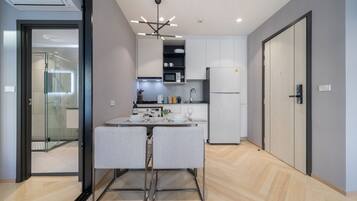 Una cocina moderna con microondas incorporado, refrigerador y comedor con mesa y sillas.