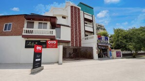 Un edificio de varios pisos con recepción, habitaciones y fachada comercial.