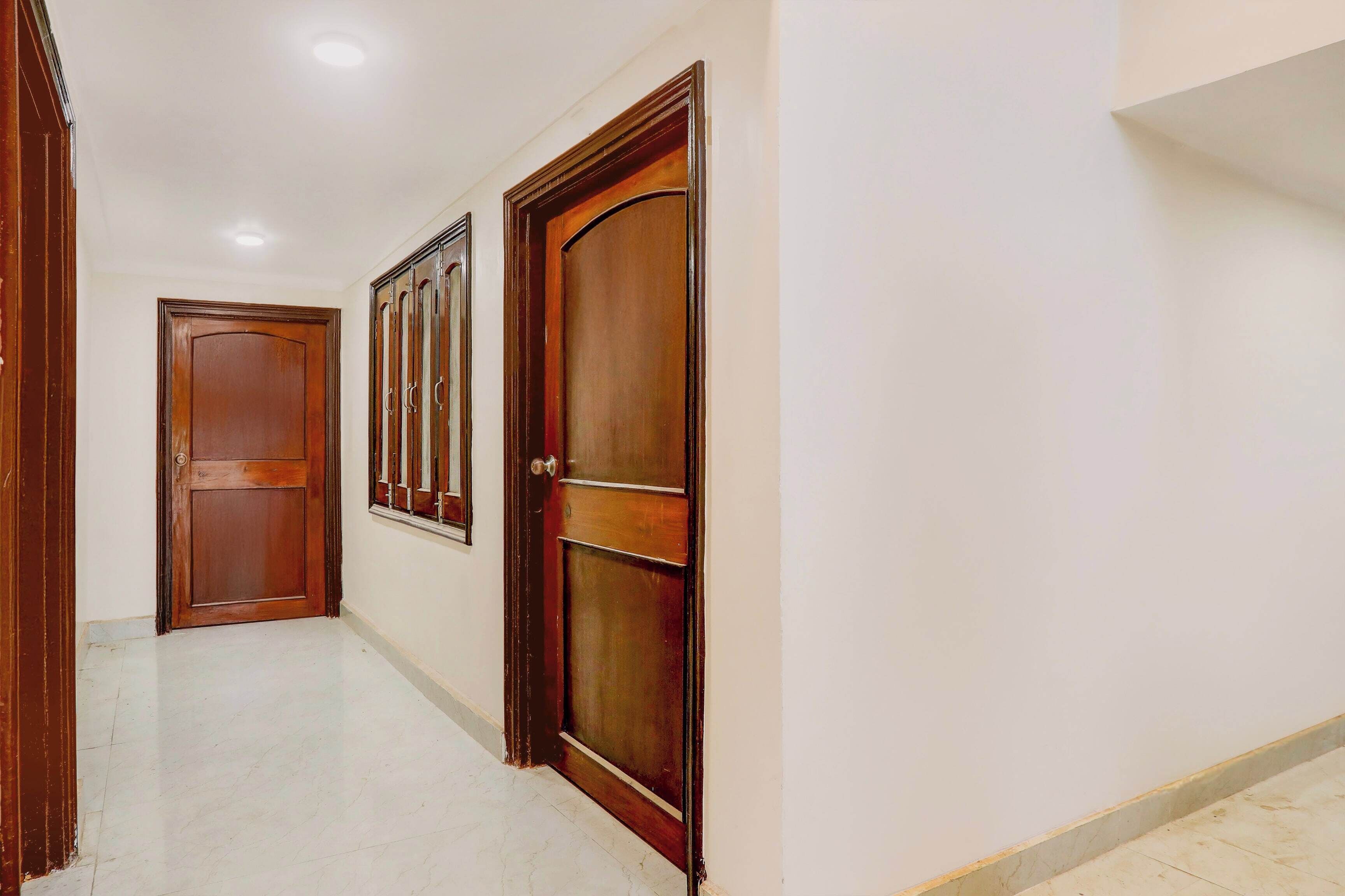 A hallway with wooden doors and a tiled floor.