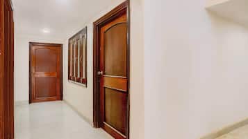 A hallway with wooden doors and a tiled floor.