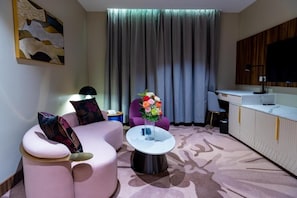A modern living room with a curved sofa, a coffee table, and a floral centerpiece.