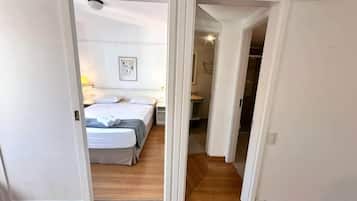 Une chambre à coucher avec un lit, une table de chevet et une commode.