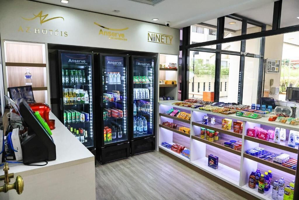 Una hall d'albergo con distributori automatici, un chiosco self-service e una selezione di snack e bevande.