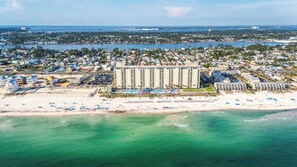 Un hôtel situé sur la côte, doté d’un grand bâtiment, donnant sur la plage et offrant une vue sur la mer.