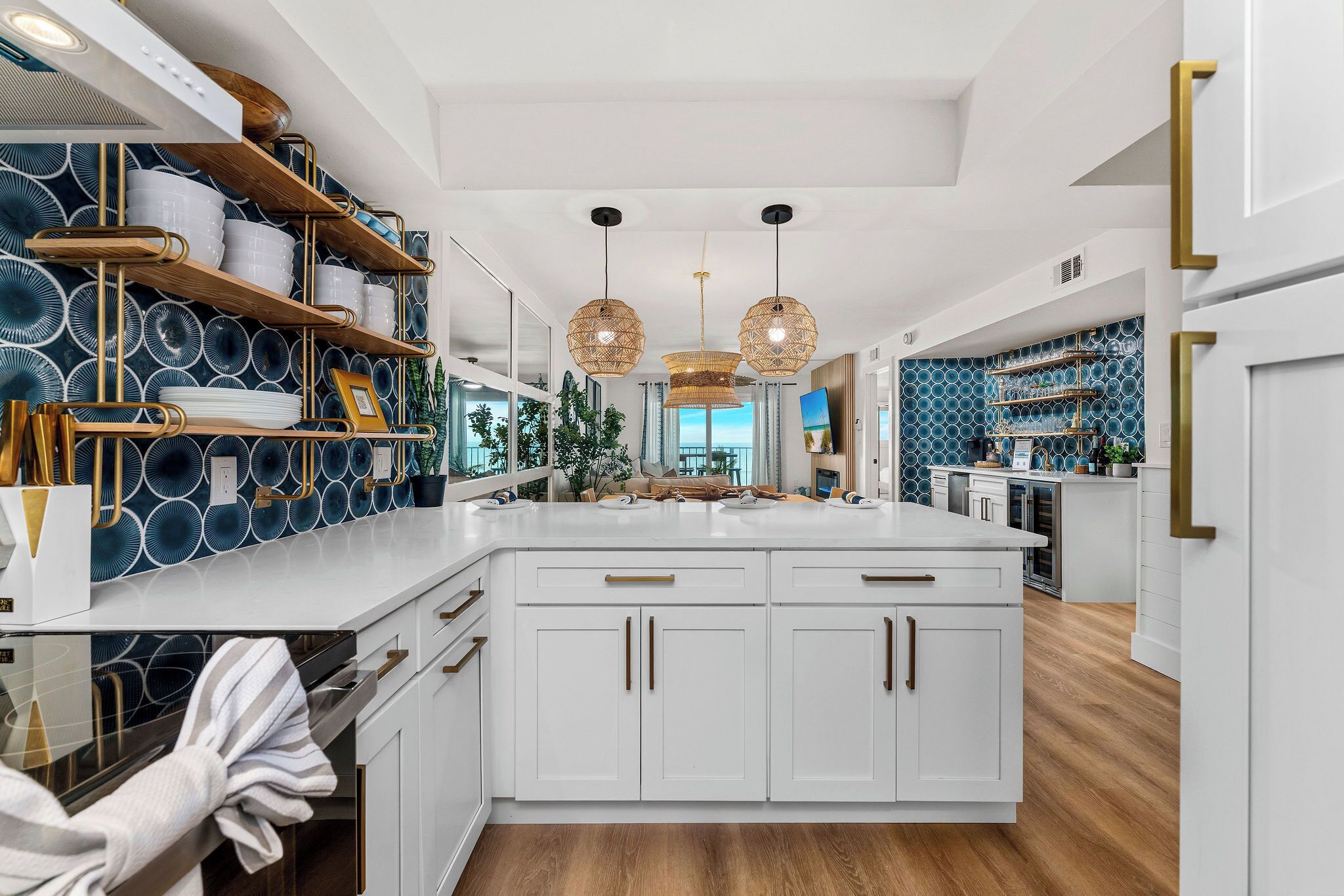 Una cocina moderna con armarios blancos, una isla central y un salpicadero con diseños circulares.