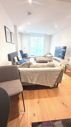 A modern bedroom with a bed, a desk, a chair, and a television. - Apartment Sleeps 6 With Balcony (London)