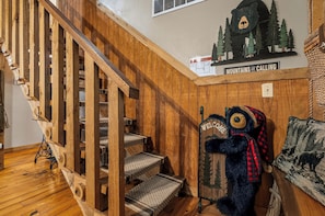 Uma escadaria de madeira com uma decoração de urso na base.