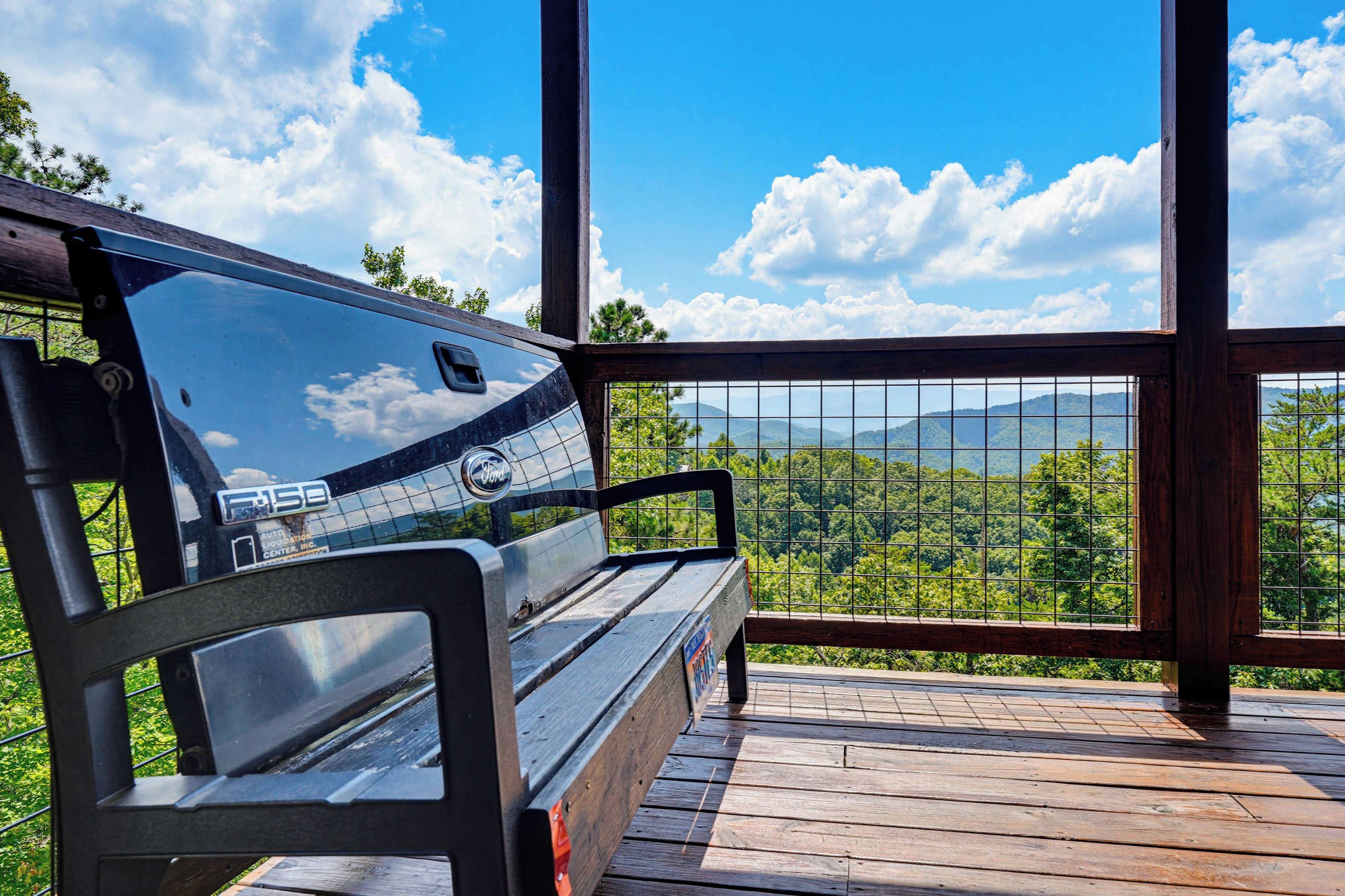 Une terrasse en bois avec un banc donnant sur un paysage montagneux.