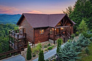 A log cabin with a balcony, a porch, and a view of the surrounding forest. - New Listing, Game Room, Hot Tub, Free Attractions, Mountain View (Sevierville)