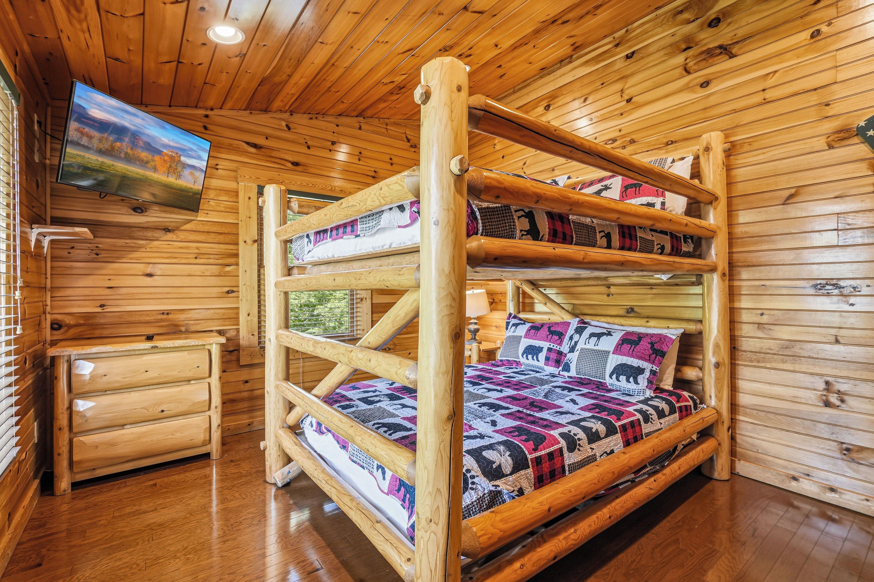 Ein Stockbett mit Fernseher darüber, Holzwände und eine kleine Holzkommode.