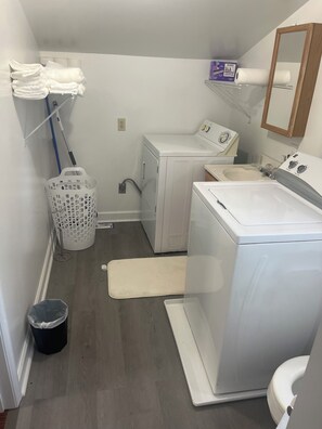 A laundry room with a washing machine, dryer, and a utility sink.