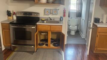 A compact kitchen with a built-in oven, a sink, and wooden cabinets.