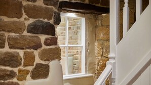 A stone wall with a window and a white staircase. - Host Stay - Hidden Winds Cottage (Guisborough)