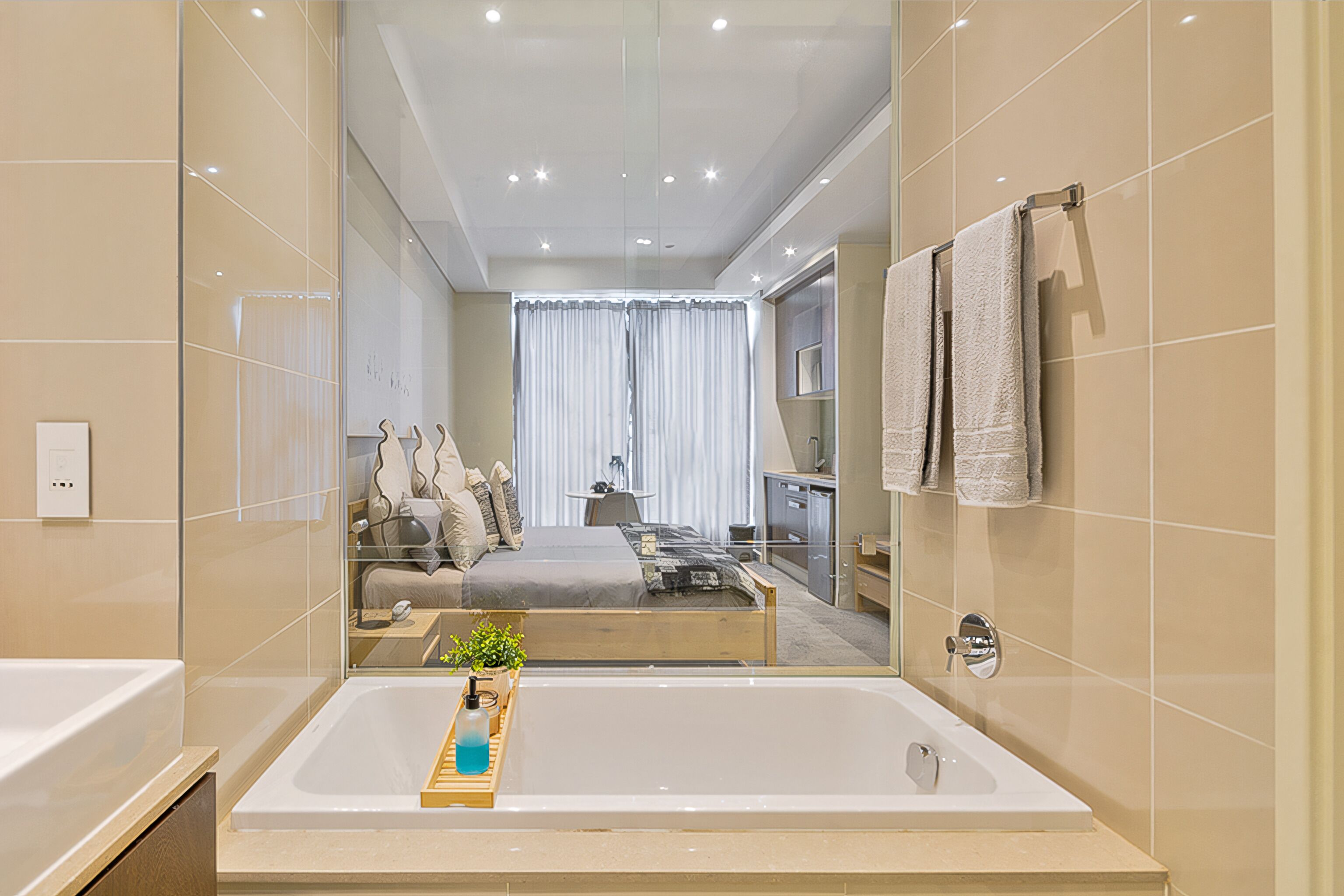 A modern bathroom with a large bathtub, a mirror, and a shower area.