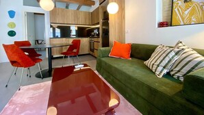 A modern living room with a glass coffee table, a green sofa with striped pillows, and a red chair. - 1BR near Malvarrosa beach Cabanyal R53 (Valencia / València)