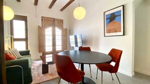 A dining area with a round table, red chairs, and a painting on the wall. - 1BR near Malvarrosa beach Cabanyal R53 (Valencia / València)