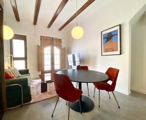 A dining area with a round table, red chairs, and a painting on the wall. - 1BR near Malvarrosa beach Cabanyal R53 (Valencia / València)